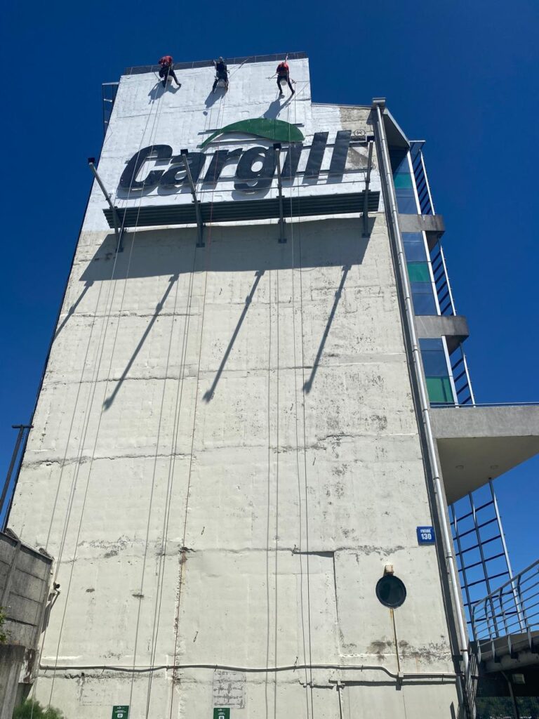 Equipo de técnicos en rapel trabajando en la fachada del edificio Cargill, Puerto Montt