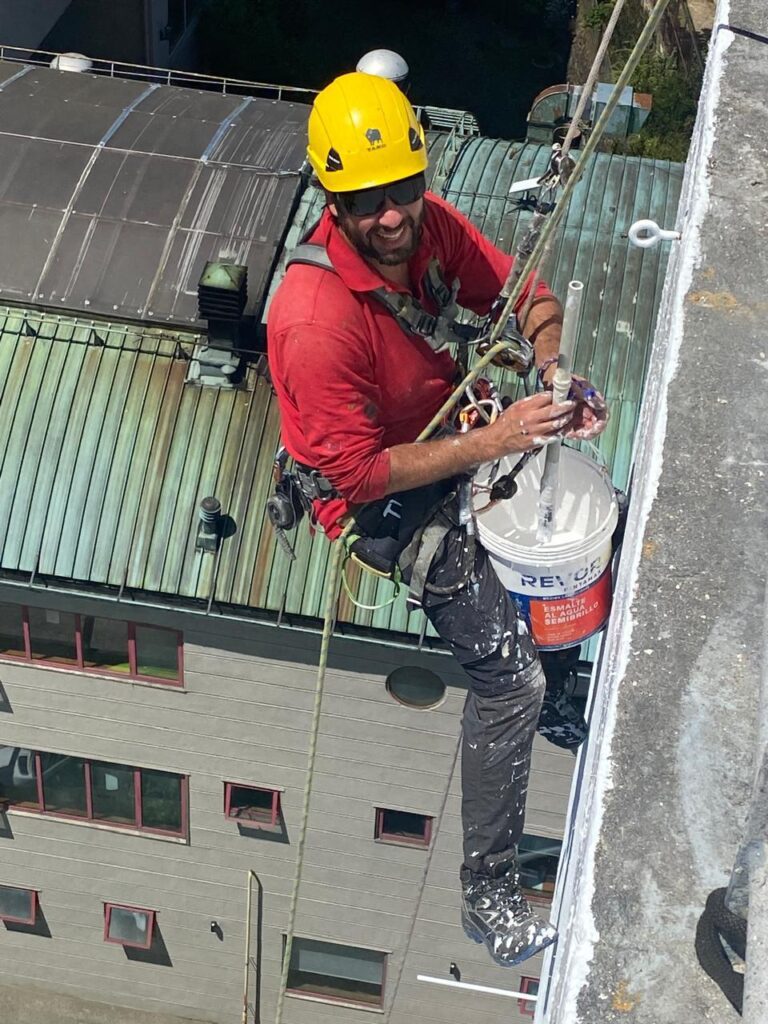 Técnico de Austral Patagonia aplicando pintura en altura, edificio Cargill